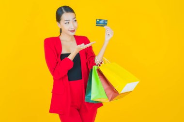 Portre güzel Asyalı kadın tebessümü ile renk arka planında alışveriş torbası