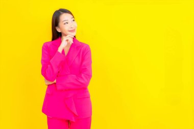 Güzel bir Asyalı kadın sarı arka planda gülümsüyor.