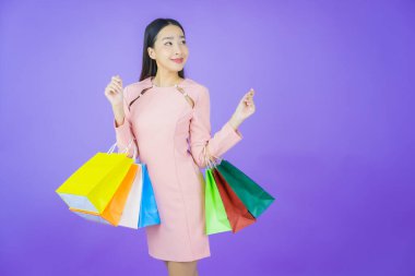 Portre güzel Asyalı kadın tebessümü ile renk arka planında alışveriş torbası