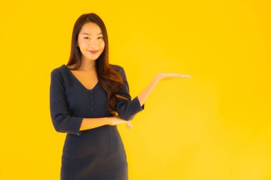 İzole edilmiş sarı arka planda hareketli güzel Asyalı kadın portresi.