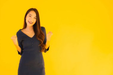 İzole edilmiş sarı arka planda hareketli güzel Asyalı kadın portresi.