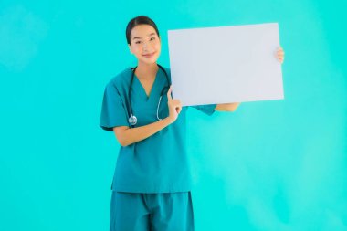 Fotokopi için boş kâğıt tahtası olan güzel Asyalı genç doktor kadın hastane ve klinikteki sağlık hizmetleri konseptinde mavi izole edilmiş arka plan.