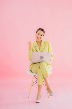 Güzel Asyalı iş kadını portresi renk arkaplanda bilgisayar bilgisayarı kullanıyor