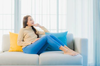 Güzel bir Asyalı kadın portresi. Rahat ol. Oturma odasının iç kısmındaki kanepede keyfine bak.