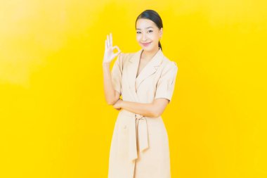 Portre güzel Asyalı kadın gülümsüyor. Renkli arka planda hareket var.