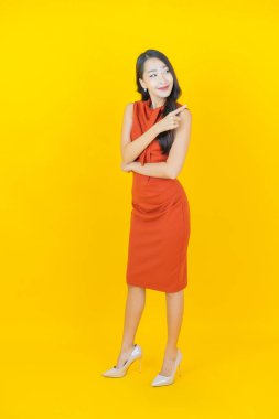 Portre güzel Asyalı kadın gülümsüyor. Renkli arka planda hareket var.