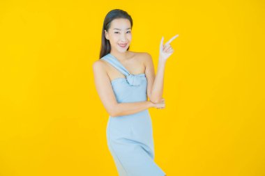 Portre güzel Asyalı kadın gülümsüyor. Renkli arka planda hareket var.