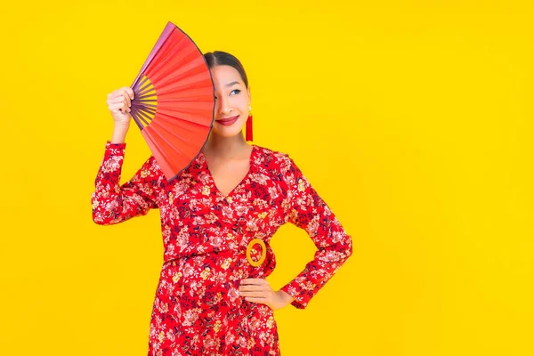 在中国新年的色彩背景观念中 年轻美丽的亚洲女人在行动中的微笑 — 图库照片