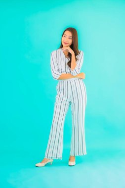 Asyalı güzel bir kadının portresi mavi izole edilmiş arka planda gülümsüyor.