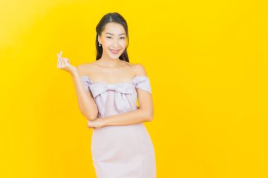 Portre güzel Asyalı kadın gülümsüyor. Renkli arka planda hareket var.