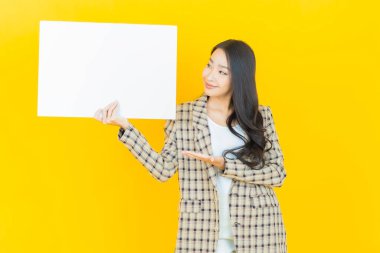 Renkli arka planda boş beyaz ilan panosu olan güzel Asyalı kadın portresi