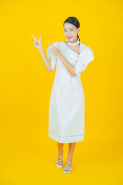 Portre güzel Asyalı kadın gülümsüyor. Renkli arka planda hareket var.