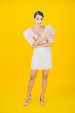 Portre güzel Asyalı kadın gülümsüyor. Renkli arka planda hareket var.