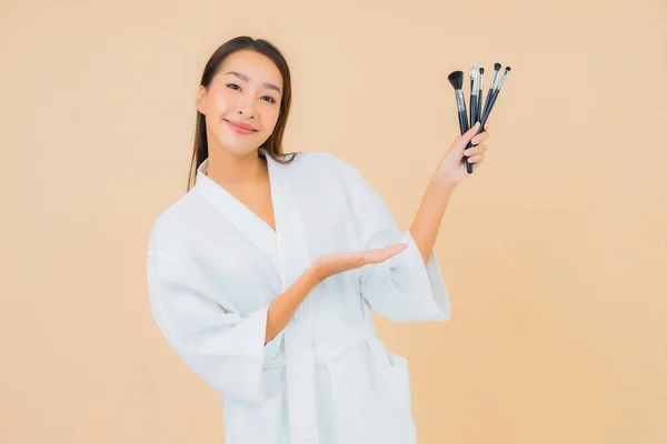 Renkli Arka Planda Makyaj Fırçası Olan Güzel Bir Asyalı Kadın — Stok fotoğraf