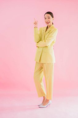 Portre güzel Asyalı genç iş kadını pembe arka planda gülümsüyor