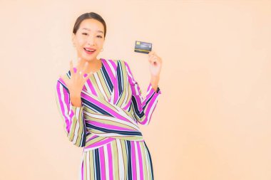 Akıllı cep telefonu ve kredi kartı olan güzel bir Asyalı kadın portresi.