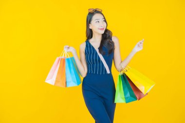 Portre güzel Asyalı kadın tebessümü ile renk arka planında alışveriş torbası
