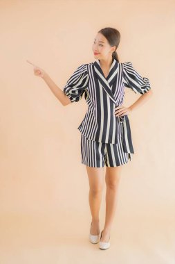 Güzel bir Asyalı kadının portresi. Kahverengi arka planda mutlu bir gülümseme.