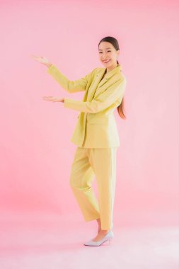 Portre güzel Asyalı genç iş kadını pembe arka planda gülümsüyor