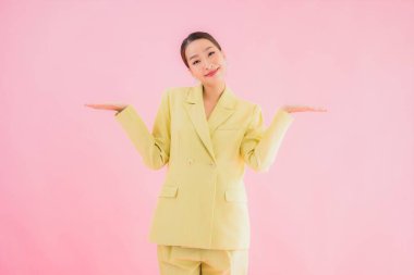 Portre güzel Asyalı genç iş kadını pembe arka planda gülümsüyor