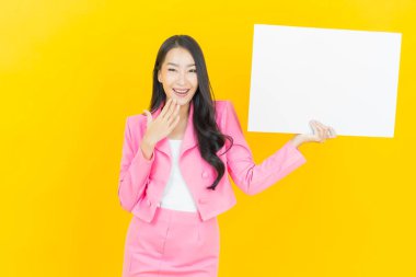 Sarı arka planda boş beyaz ilan panosu olan güzel Asyalı kadın portresi
