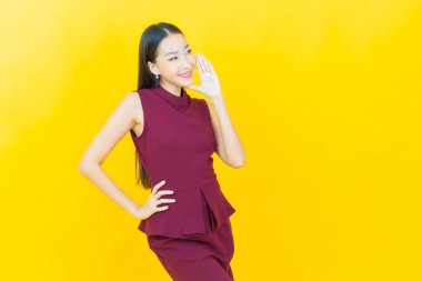 Portre güzel Asyalı kadın gülümsüyor. Renkli arka planda hareket var.