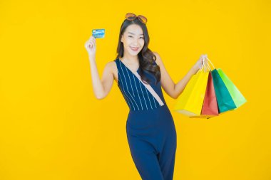 Portre güzel Asyalı kadın tebessümü ile renk arka planında alışveriş torbası