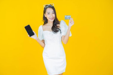 Güzel bir Asyalı kadının portresi. Renkli kredi kartıyla gülüyor.