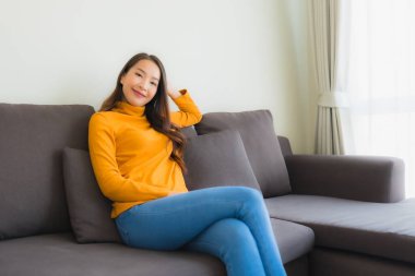 Genç Asyalı kadının portresi mutlu. Rahat ol. Koltukta gülümse.