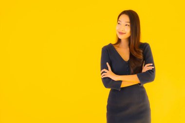 İzole edilmiş sarı arka planda hareketli güzel Asyalı kadın portresi.