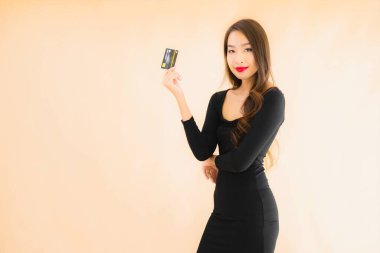 Renkli arka planda alışveriş yapmak için kredi kartı olan güzel bir Asyalı kadın portresi.