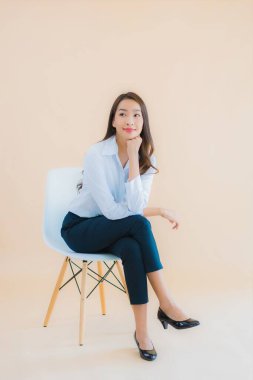 Güzel bir iş kadını portresi. Sandalyeye dizüstü bilgisayarı ya da iş için akıllı telefonu olan bir kadın.