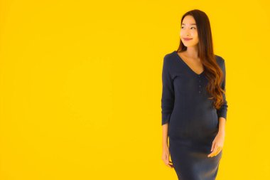 İzole edilmiş sarı arka planda hareketli güzel Asyalı kadın portresi.