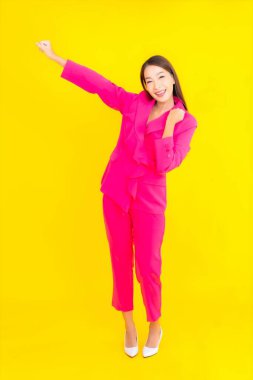 Güzel bir Asyalı kadın sarı arka planda gülümsüyor.