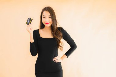 Renkli arka planda alışveriş yapmak için kredi kartı olan güzel bir Asyalı kadın portresi.