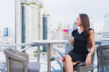 Güzel bir Asyalı kadın portresi. Kokteyllerle eğleniyor. Barda ve restoranda bardak içiyor.