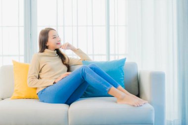 Güzel bir Asyalı kadın portresi. Rahat ol. Oturma odasının iç kısmındaki kanepede keyfine bak.