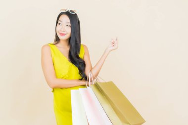 Portre güzel Asyalı kadın tebessümü ile renk arka planında alışveriş torbası