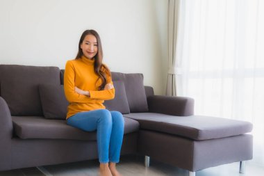 Genç Asyalı kadının portresi mutlu. Rahat ol. Koltukta gülümse.