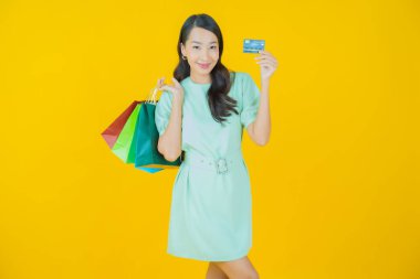 Portre güzel Asyalı kadın tebessümü ile renk arka planında alışveriş torbası