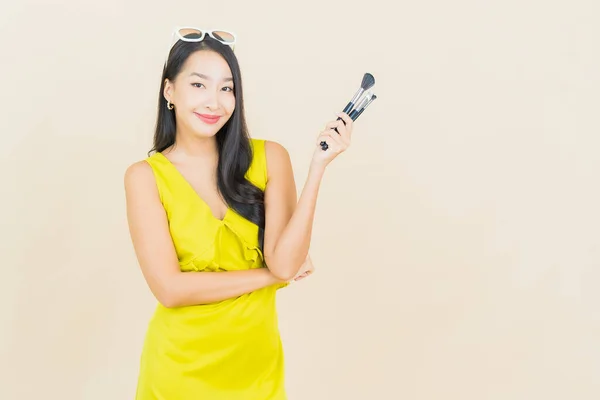 色彩艳丽的年轻亚洲女子与化妆品彩绘画笔背景 — 图库照片