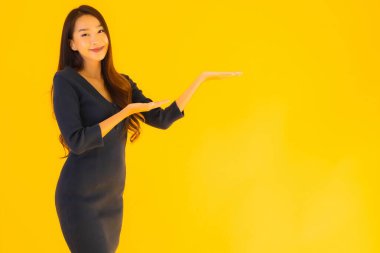 İzole edilmiş sarı arka planda hareketli güzel Asyalı kadın portresi.