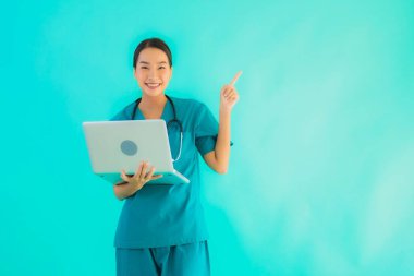 Mavi izole arka planda dizüstü bilgisayarı olan güzel Asyalı doktor kadın portresi.
