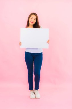 Portrait beautiful young asian woman show empty white billboard for text on pink color background