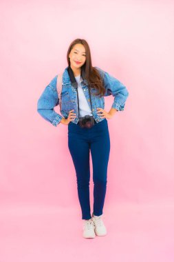 Portrait beautiful young asian woman backpack or luggage with camera ready for travel in vacation on pink background