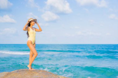 Güzel bir Asyalı kadının portresi. Rahatlayın. Plaj okyanusunda tatil yaparken gülümseyin.