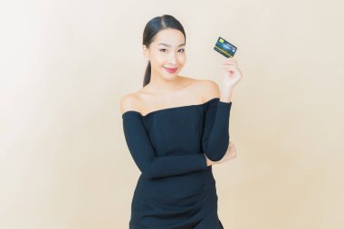 Güzel bir Asyalı kadının portresi. Renkli kredi kartıyla gülüyor.