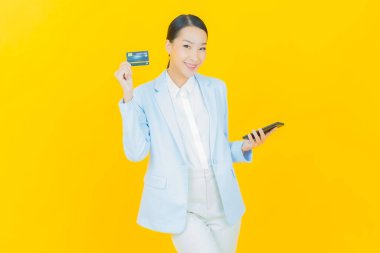 Güzel bir Asyalı kadının portresi. Renkli kredi kartıyla gülüyor.