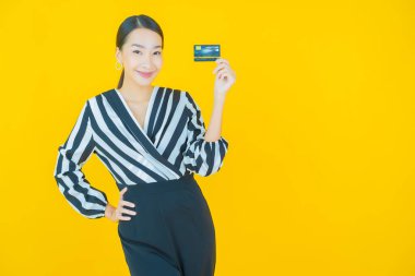 Güzel bir Asyalı kadının portresi. Renkli kredi kartıyla gülüyor.