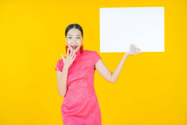 Renkli arka planda boş beyaz ilan panosu olan güzel Asyalı kadın portresi